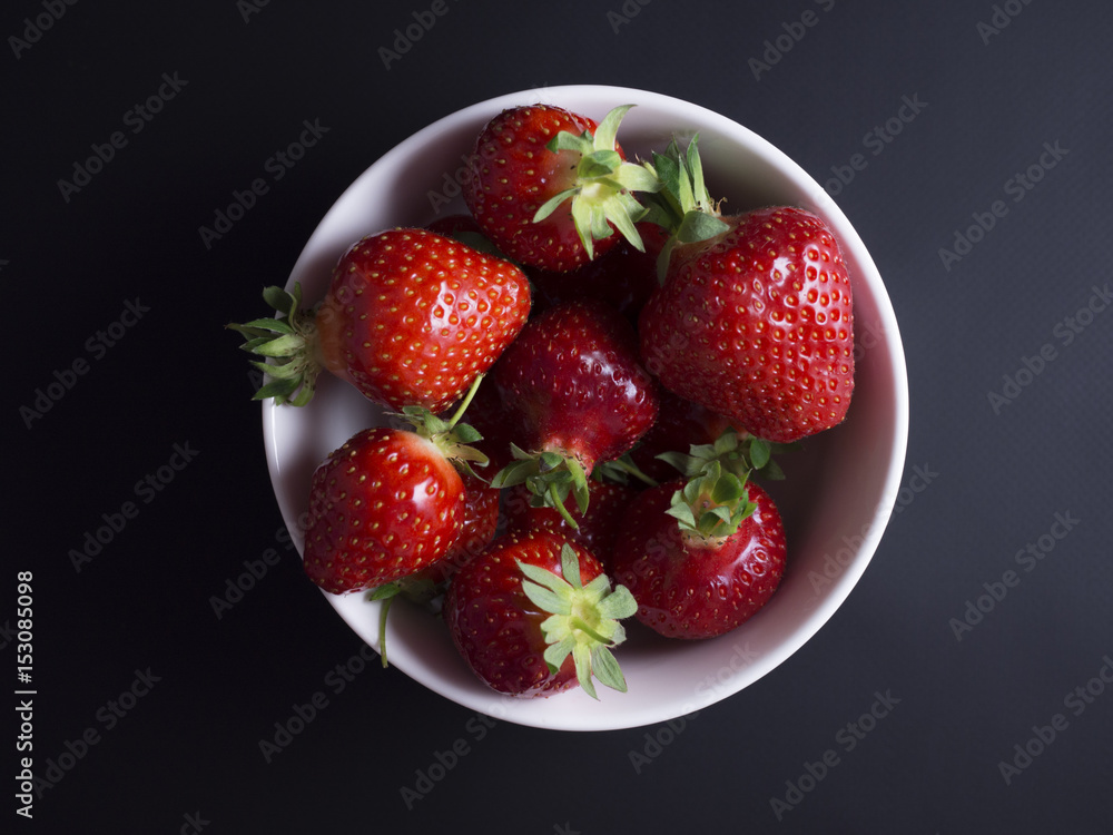 Fresh, red, ripe strawberries in white bowl isolated on black background Fresh, red, ripe strawberries in white bowl isolated on black background