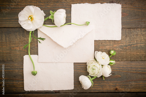Vintage background made of paper post cards, envelope and white flowers on wood background. Flat lay, top view.