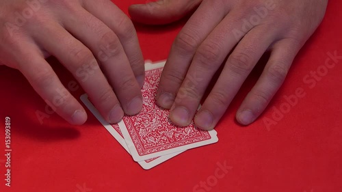 Human hand opening two cards in poker game.
