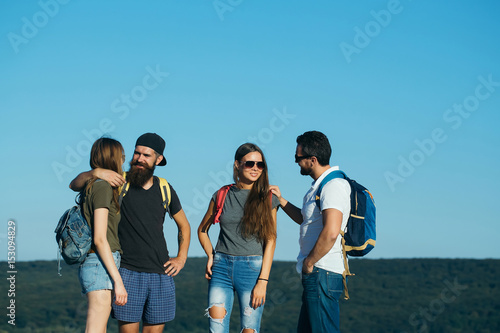 Happy, smiling friends standing on mountain top
