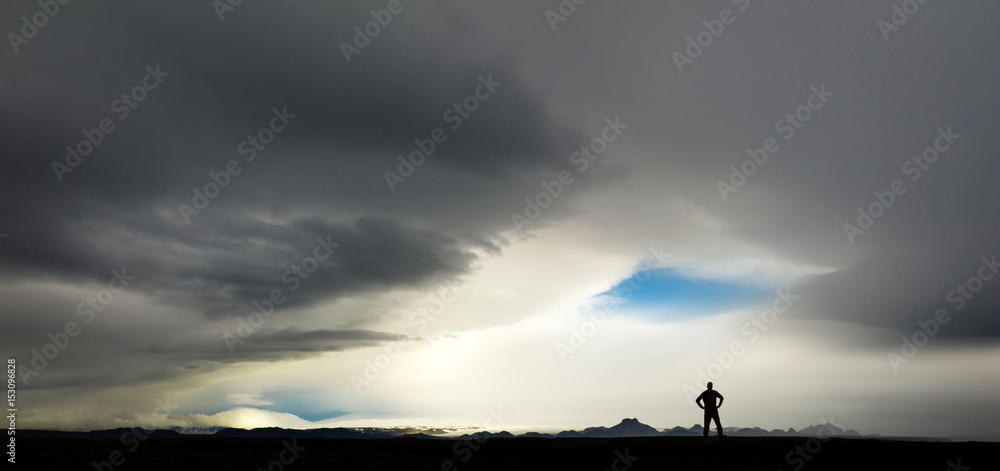 Silhouette of man watching huge storm and clouds in Iceland