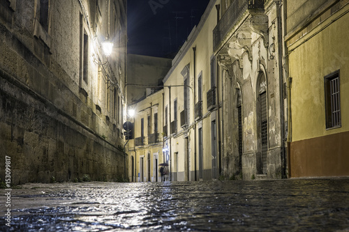 Street in Brindisi by night with disappearing couple, Italy