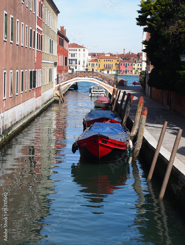 venice canal with red boat and bridge