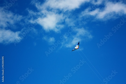 Kite flying on the beach against the background of a beautiful blue sky.