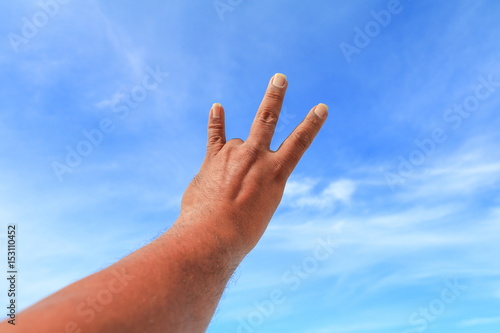 hand show counting number three on sky background