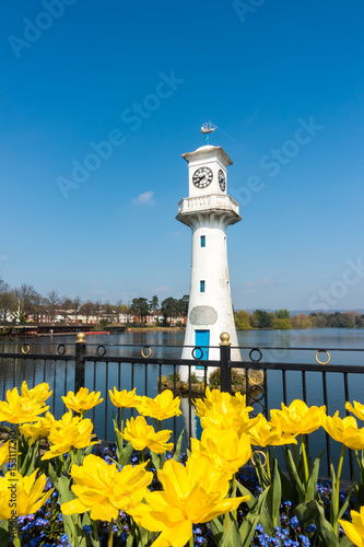 Yellow Tulips blooming in front of the Robert Scott Memorial Lighthouse at Roath Park Lake, Cardiff, Wales, UK. 

