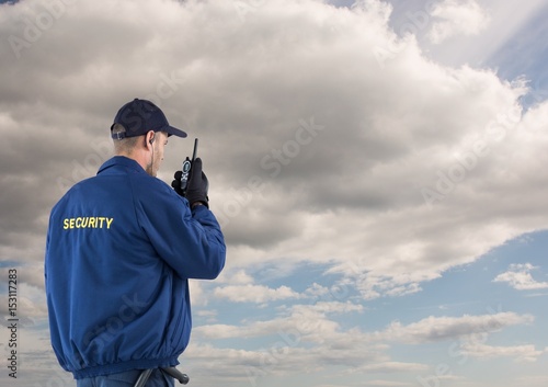Rear view of security guard using radio 