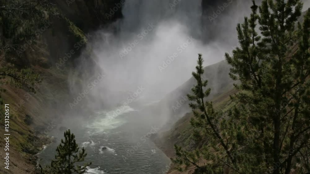 close up of the bottom of a giant waterfall in a canyon surrounded by trees close up of the bottom of a giant waterfall in a canyon surrounded by trees