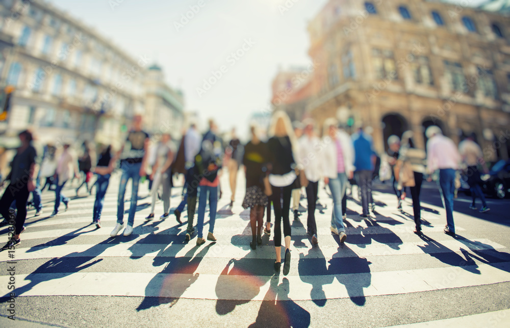 Obraz premium Crowd of anonymous people walking on sunset in the city streets