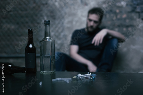 Alcohol in bottles and used syringes lying on the table photo