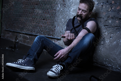 Tableau sur toile Desperate drug addict making heroin injection in the darkness