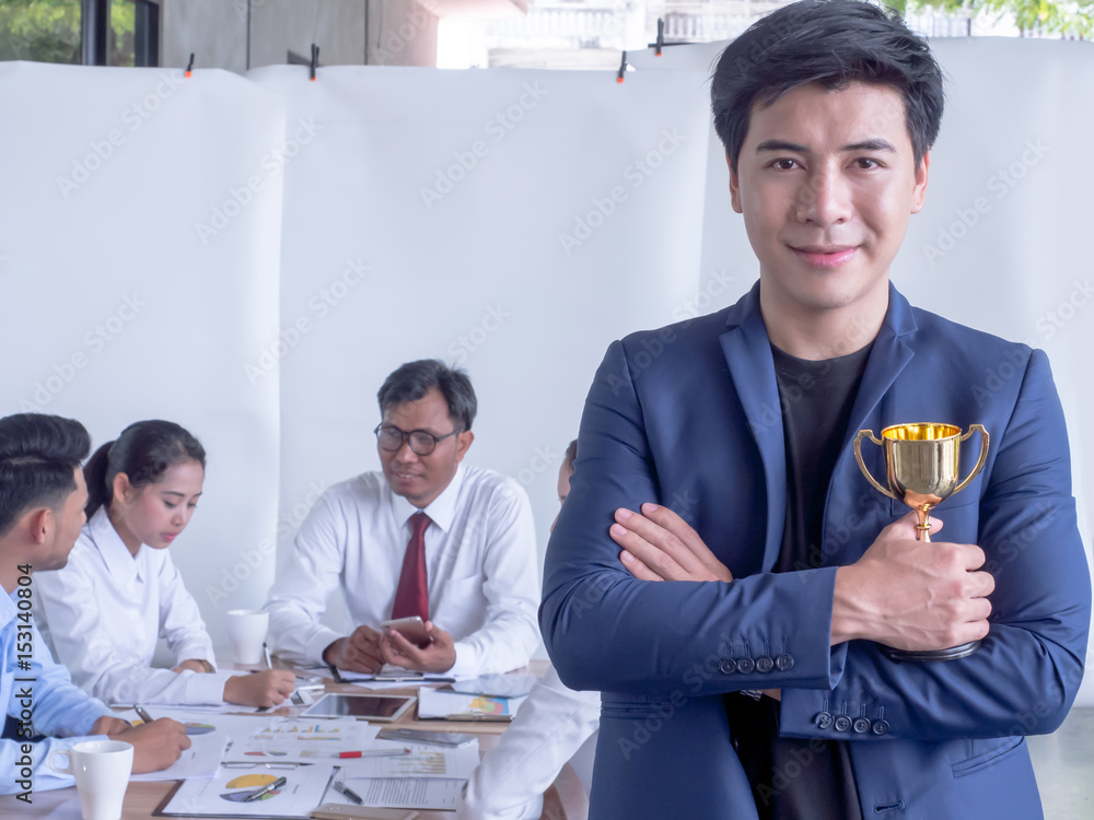 Businessman holding trophy and smiling. Businessman man colleague at a meeting Businessman holding trophy and smiling. Businessman man colleague at a meeting