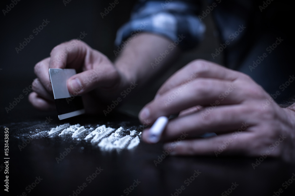 Obraz premium Drug addicted preparing heroin lines in the dark place