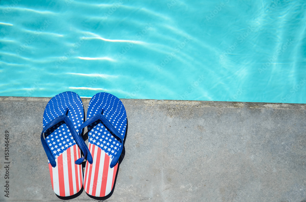 Naklejka premium Summer background with flip flops near the pool