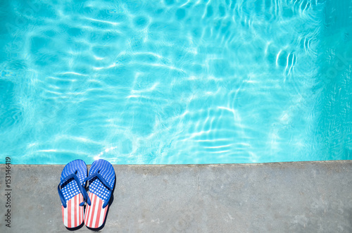 Summer background with flip flops near the pool