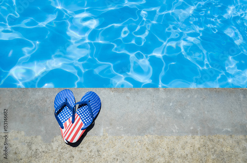 Summer background with heart of flip flops near the pool