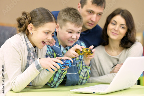 Happy family with children behind laptop