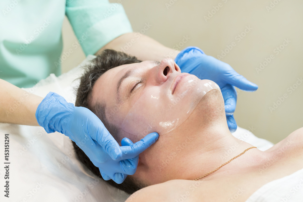Man in the mask cosmetic procedure in spa salon Man in the mask cosmetic procedure in spa salon