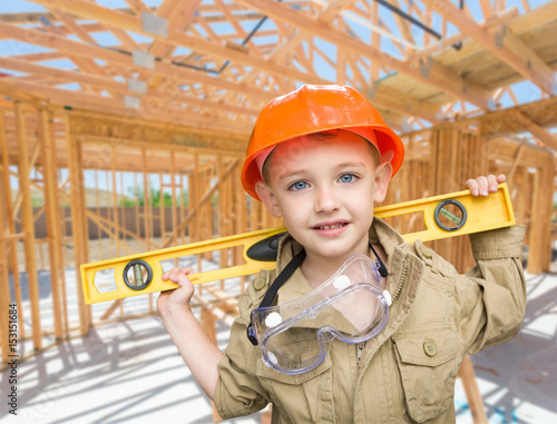 Young Boy Contractor With Level On Site Inside New Home Construction Framing. photo