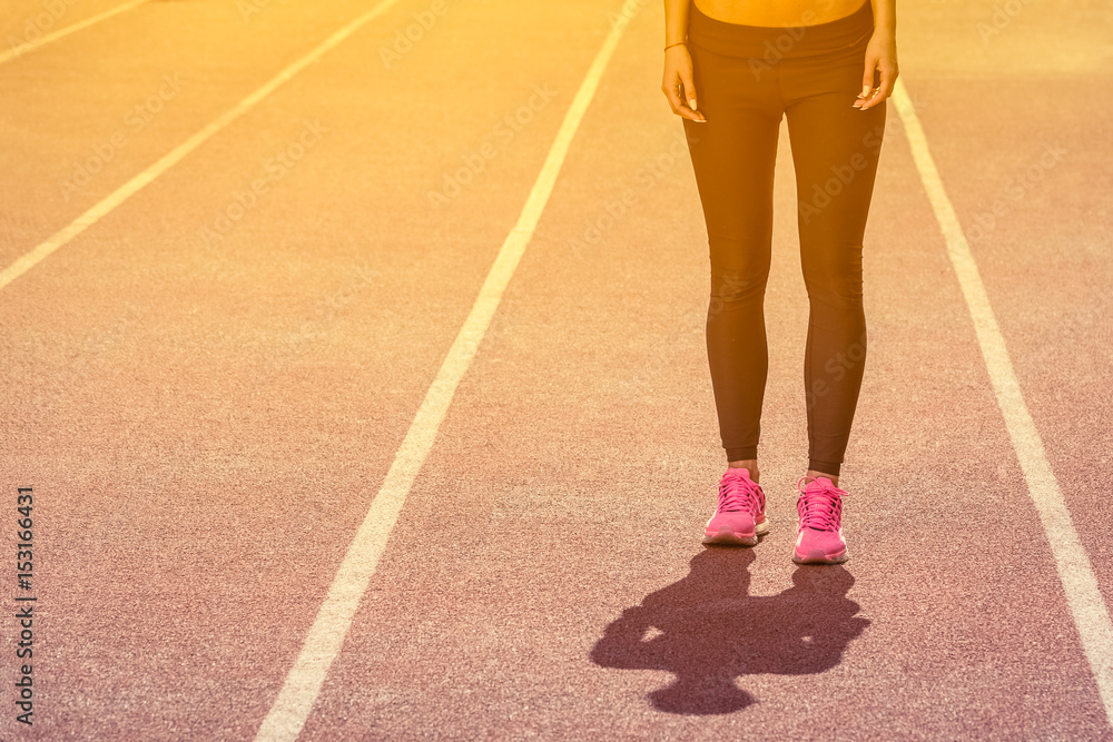 Sportswoman standing on running track