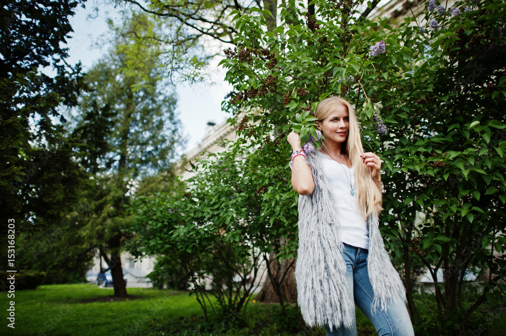 Stylish blonde woman wear at jeans and girl sleeveless with white shirt against lilac. Fashion urban model portrait. Stylish blonde woman wear at jeans and girl sleeveless with white shirt against lilac. Fashion urban model portrait.
