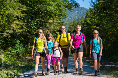 Schilderij op canvas Familie mit vier Kindern beim Wandern in den Bergen