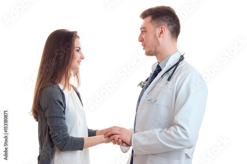 smiling young girl stands opposite the doctor and kept him hands