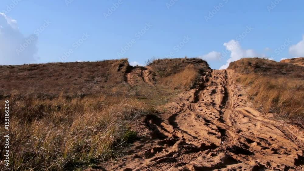 Off Road Sand Dune Motocross and Auto Sport Track on Blue Sky and White Clouds Background . Camera Moves Down Off Road Sand Dune Motocross and Auto Sport Track on Blue Sky and White Clouds Background . Camera Moves Down