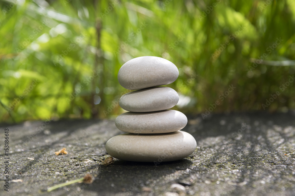 Harmony and balance, simple pebbles tower in the grass, simplicity, four stones