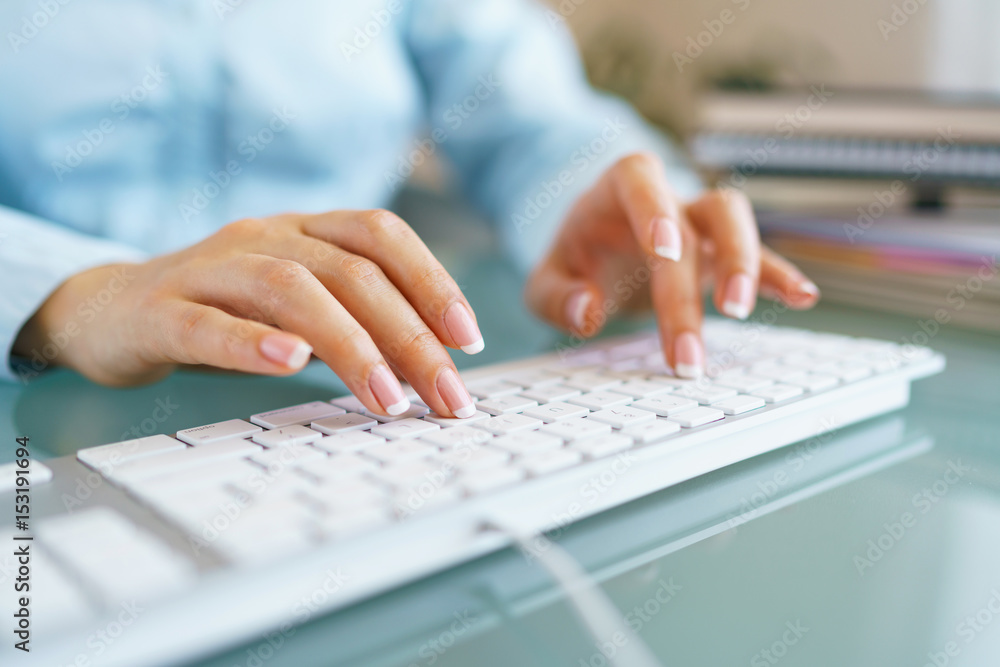 Woman office worker typing on the keyboard