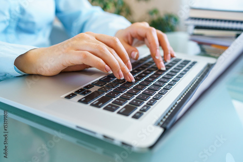 Woman office worker typing on the keyboard