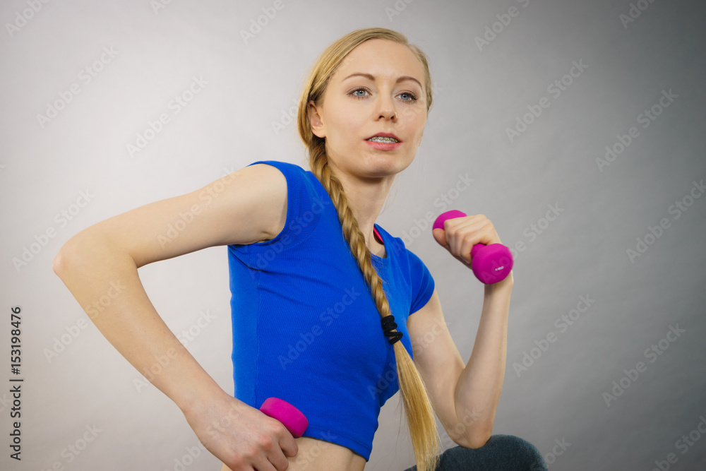 Teenage woman working out at home with dumbbell Teenage woman working out at home with dumbbell