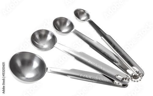 Set of metal measuring spoons of different sizes. Isolated on white background.