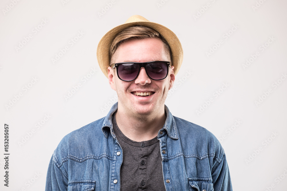 Portrait of attractive young man in hat and sunglasses over white background Portrait of attractive young man in hat and sunglasses over white background