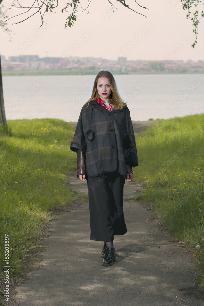 Blond girl posing near lake shore in a cold spring day Blond girl posing near lake shore in a cold spring day