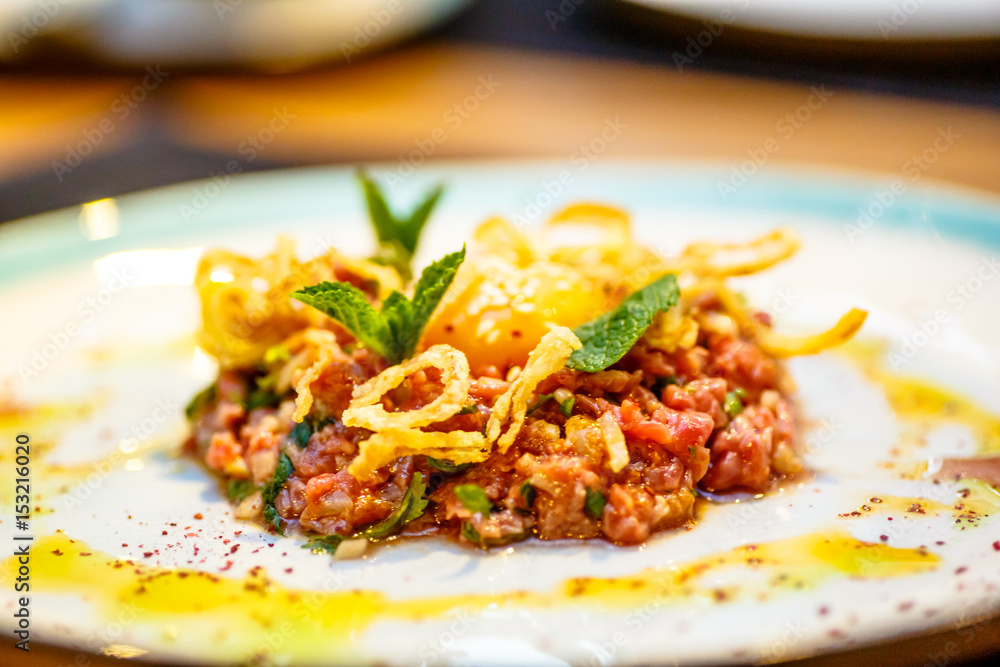 Beef tartare with fried onion lies on the plate. Beef tartare with fried onion lies on the plate.