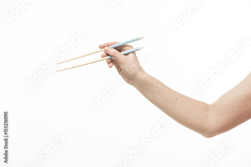 Hand with Chinese chopsticks and pencils