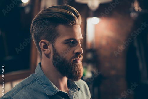Barbershop concept. Profile side portrait of attractive severe brutal red bearded young guy. He has a perfect hairstyle, modern stylish haircut photo