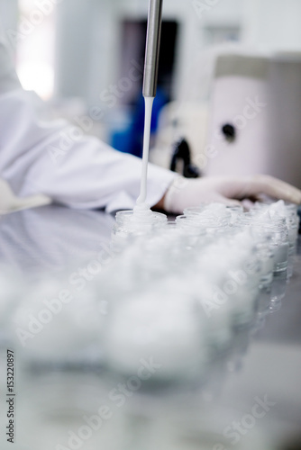 Production and packaging of cosmetic products. Cremes being filled in glass packaging.