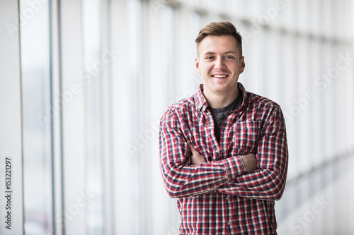 Free Download Portrait of smiling man standing with hands crossed in modern building - GFXLoad