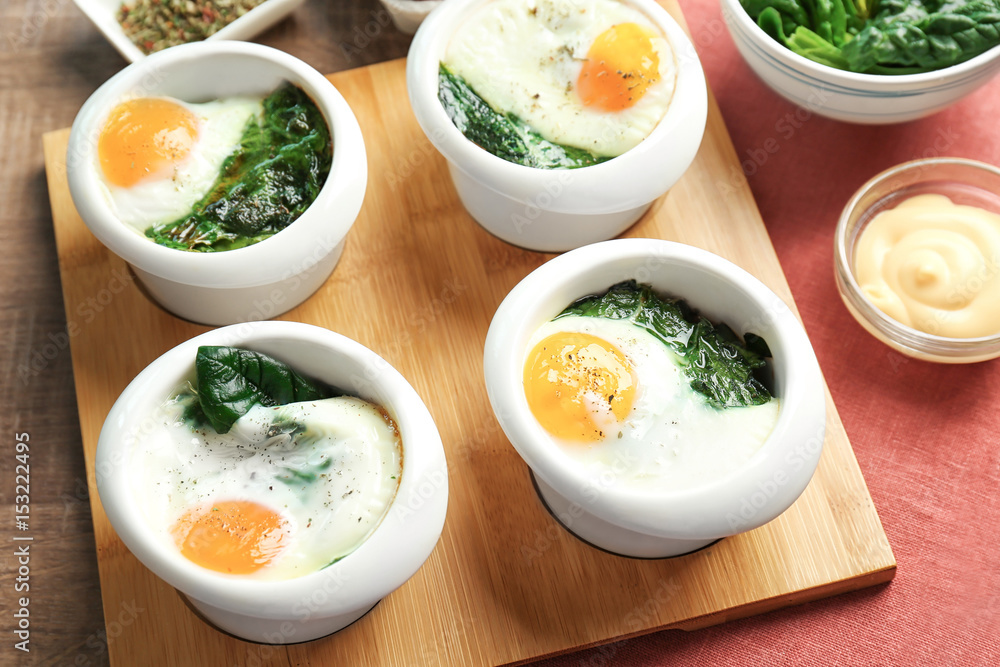 Bowls with tasty eggs and spinach, closeup Bowls with tasty eggs and spinach, closeup