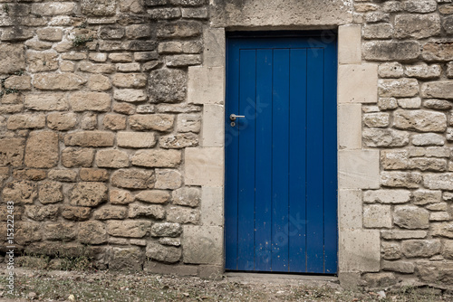 Blue wooden door on a grey stone wall