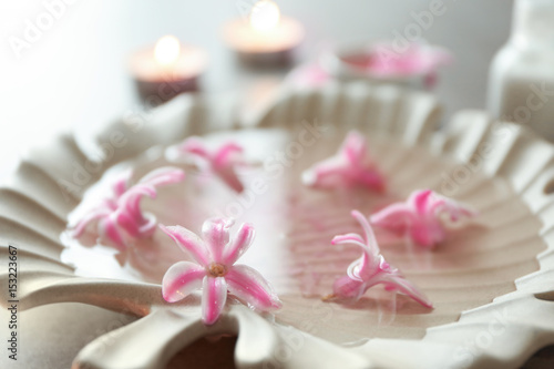 Plate in shape of leaf with flower petals on water  closeup