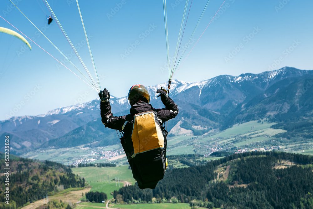 Obraz premium Paraglider is on the paraplane strops - soaring flight moment