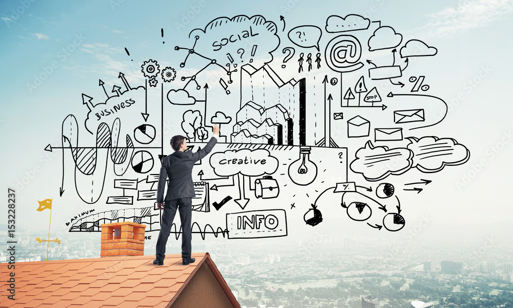 Rear view of businessman on house roof drawing his new business Rear view of businessman on house roof drawing his new business