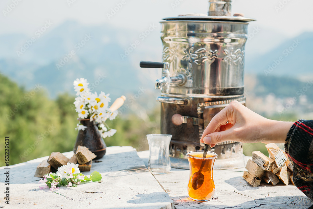 Fototapeta premium Hand holding spoon and tulip-shaped tea glass