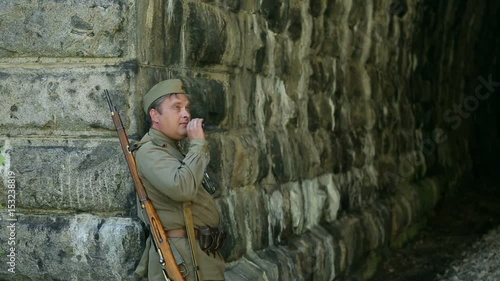 Actor dressed in military uniforms. Soldiers of the Soviet army smokes. The army of the USSR. A soldier with a rifle guarding a railway tunnel.