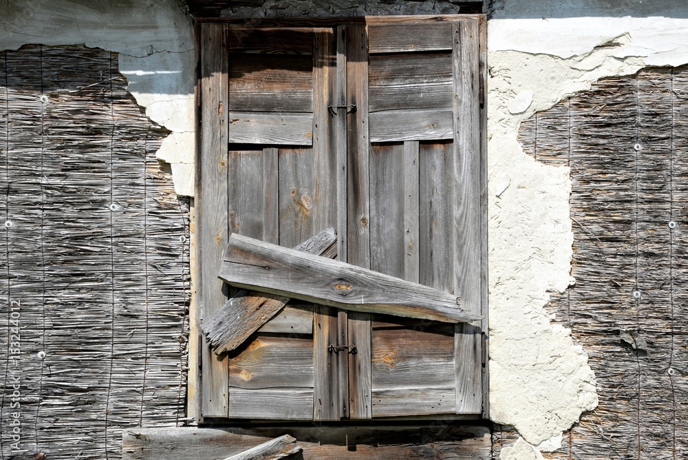Window of an old wooden abandoned house demolishing in the wilderness