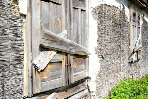Window of an old wooden abandoned house demolishing in the wilderness