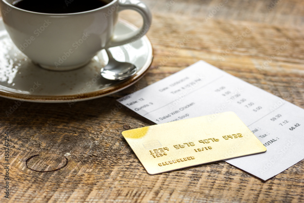 coffee and receipt bill for payment by credit card on wooden table background coffee and receipt bill for payment by credit card on wooden table background
